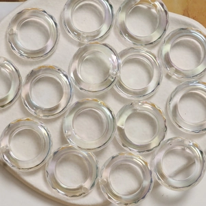 Detailed view of iridescent faceted acrylic rings with pre-drilled holes for DIY jewelry