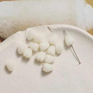 Macro detail of white tulip-shaped resin beads for DIY jewelry and beaded accessories
