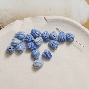 Macro detail of tulip bud spacer beads in gradient blue for DIY jewelry making