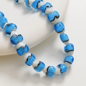 Vue macro des perles en verre rayées de 15 mm en forme de cœur pour bijoux