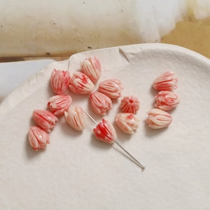 Macro shot of tulip-shaped shell beads in pink and white for DIY jewelry making