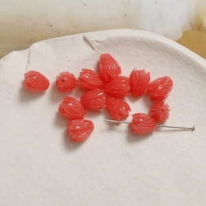 Detailed macro view of coral red tulip bud beads for DIY jewelry and earring making