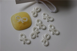 Detail view of pearl beaded bow charms for nail art and DIY jewelry crafting