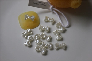 Detailed view of 12 pieces mini bowknot pearl charms for DIY nail art and shoe decoration