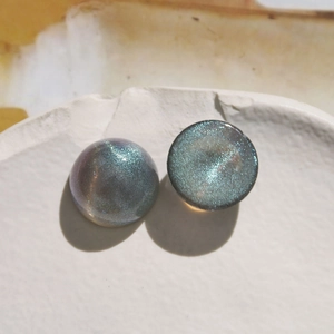Macro detail of 18mm starry blue iridescent acrylic cabochons with sparkling glitter