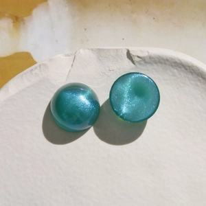 Macro detail of 18mm galaxy effect acrylic dome cabochons with sparkling blue glitter