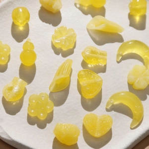 Variety of bright yellow translucent resin beads in moon heart and flower shapes for DIY jewelry