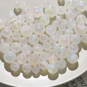 Macro view of white iridescent acrylic pearls with pearlescent finish for DIY jewelry