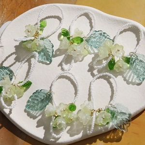 Vue détaillée d'accessoires de cheveux perlés faits main avec des fleurs de muguet vertes