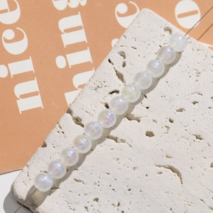 Macro detail of iridescent mermaid pearl beads for DIY jewelry making on stone background