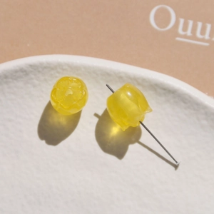 Detailed view of yellow lily of the valley resin beads with silver earring pins