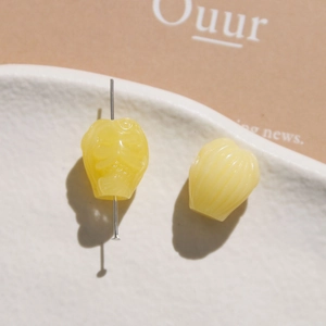 Detailed macro view of yellow resin flower beads with precise carved petal texture and hole