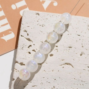 Macro shot of iridescent acrylic mermaid pearls with rainbow aurora finish on stone