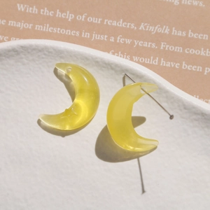 Macro shot of yellow resin crescent moon charms with star details and pre-drilled holes