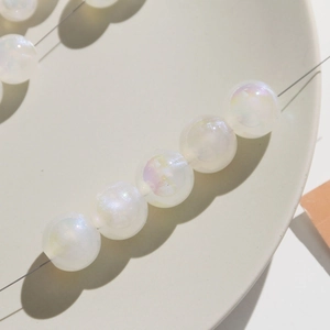 Macro view of iridescent mermaid pearl beads with AB coating on a ceramic plate