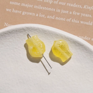 Detailed macro view of yellow resin fish beads with delicate scales for DIY jewelry making
