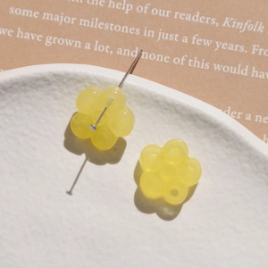 Detailed view of yellow flower resin beads with a metal pin for DIY jewelry making