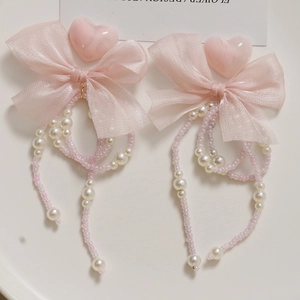 Detail of DIY long pearl chain with pink organza bow for shoe and accessory crafting
