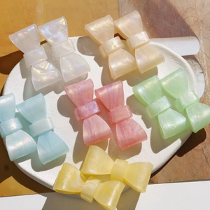 Close-up of colorful resin bow hair clips with a pearlescent aurora marble finish