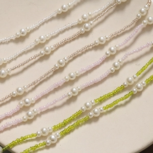 Close-up of handmade long pearl chain charms with colorful seed beads for shoes and DIY crafts