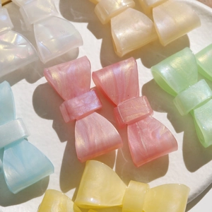 Macro shot of resin bow charms with pearlescent marble texture in macaron colors