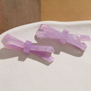 Vue macro de la texture marbrée violette sur les barrettes à cheveux en acétate chic