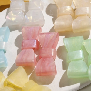 Detail of colorful bow hair clips with pearlescent marble texture on a white tray