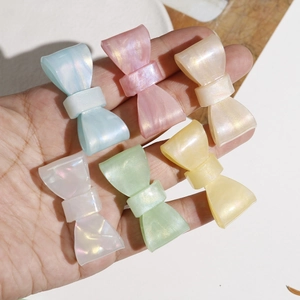 Macro detail of six iridescent colorful bow hair clips with pearlescent finish