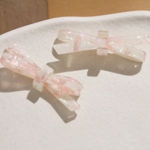 Barrette à cheveux nœud en acétate avec texture nacrée rose scintillante