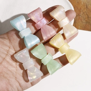 Macro detail of iridescent pearl bow hair accessories in pastel macaron colors