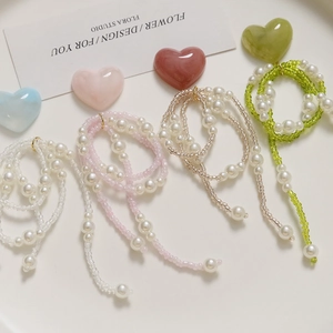 Detail of colorful pearl chain accessories for DIY shoes in white, pink and green