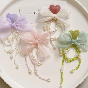 Detail of DIY pearl chain bow accessories with heart charms for shoes and hair