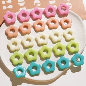 Close-up of colorful resin flower beads in five pastel shades for DIY jewelry making