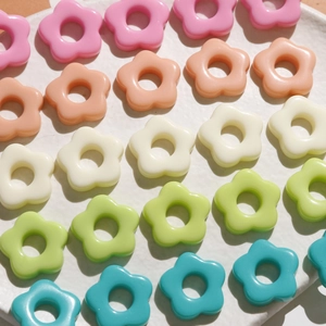 Close-up of colorful resin flower charms in five pastel colors for DIY jewelry making