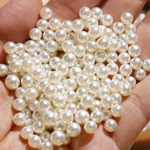 Macro-opname van 6-10 mm witte imitatieparels voor het maken van DIY-sieraden in hand