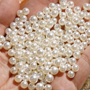 Hand met hoogglans 6mm witte ronde imitatieparels voor DIY sieraden maken