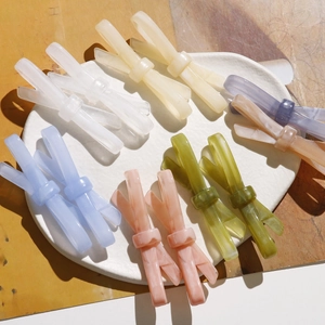 Barrettes à cheveux nœuds en acétate marbré coloré disposées sur une assiette