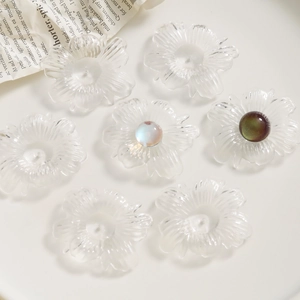 Macro view of transparent acrylic flower charms with detailed radial texture for DIY jewelry
