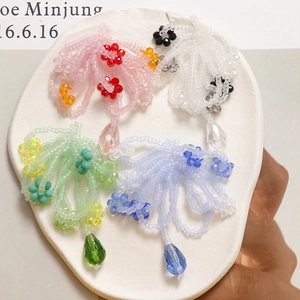 Detail of colorful beaded jellyfish charms with floral accents and teardrop pendants