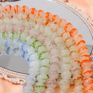 Detail of 13mm handmade glass beads with colorful interior feather spiral patterns