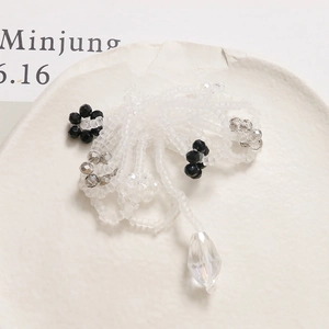 Macro shot of handmade beaded flower jewelry with frosted beads and water drop pendant
