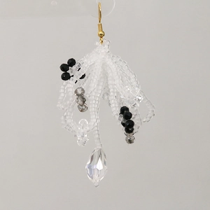 Detail of beaded tassel earring with crystal drops and gold-tone hook for women