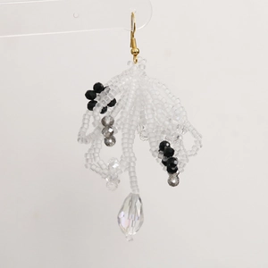 Macro detail of handmade beaded earrings with crystal drops and golden hooks