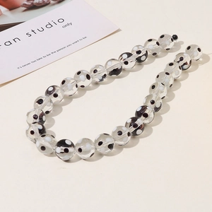 Detailed view of clear glass beads with black and white polka dots for DIY jewelry making