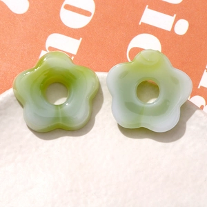 Macro view of gradient green and white hollow resin flower charms for DIY jewelry making