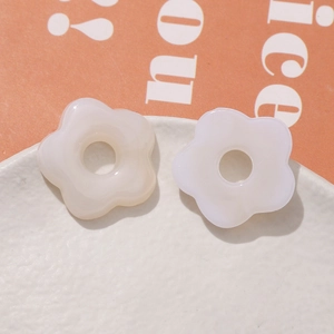 Macro view of cream-colored resin five-petal flower DIY beads with center hole