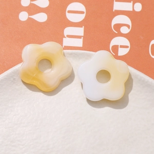Detailed close-up of marbled resin five-petal flower DIY accessories on a white plate