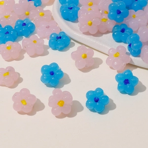 Detailed view of pink and blue resin flower beads with center holes for DIY jewelry