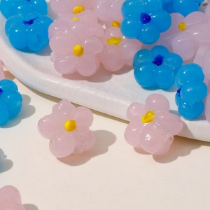 Close-up of pink and blue resin flower beads with yellow centers for DIY jewelry making