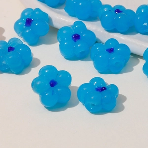 Macro shot of blue five-petal flower beads with purple stamens for DIY jewelry making